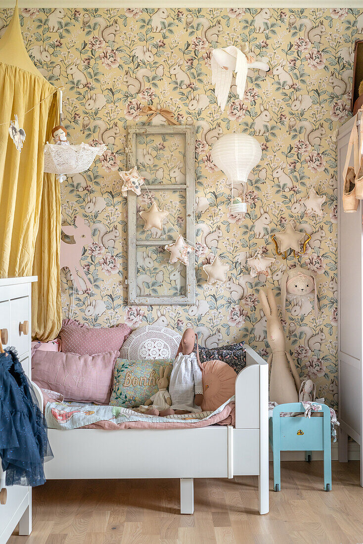 Children's room with floral wallpaper and bed with canopy