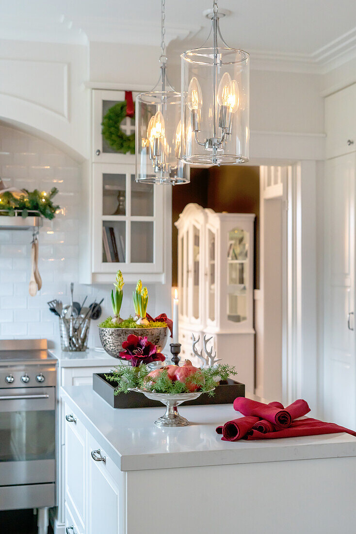 Christmas decorations and glass pendant lights in a white kitchen