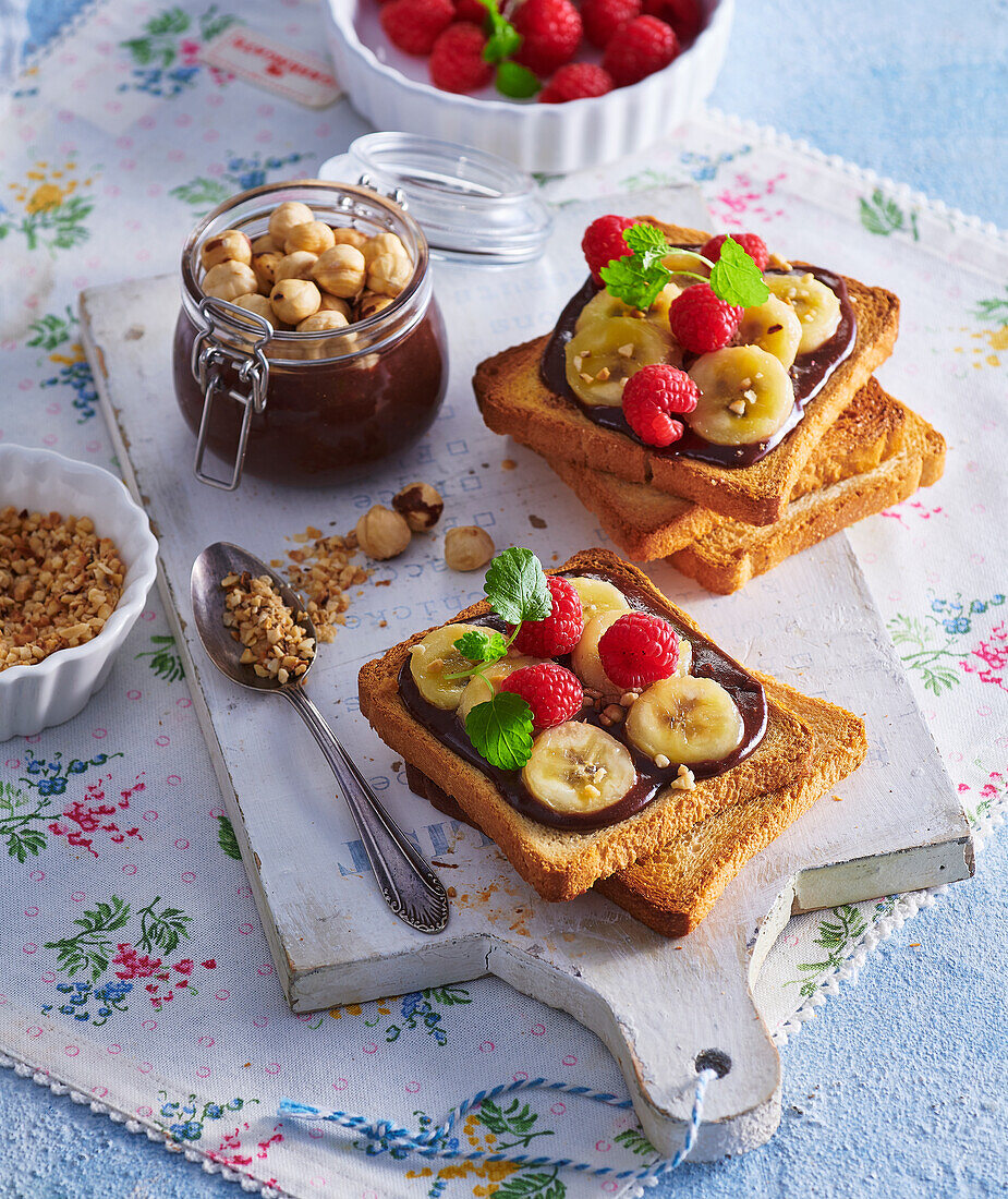 Toast with chocolate-hazelnut spread, bananas and raspberries
