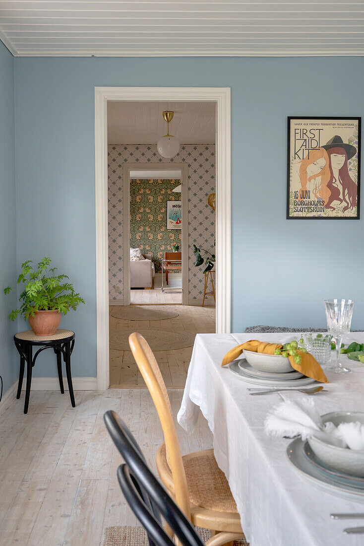 Dining room with blue walls and a view of the hallway and living room