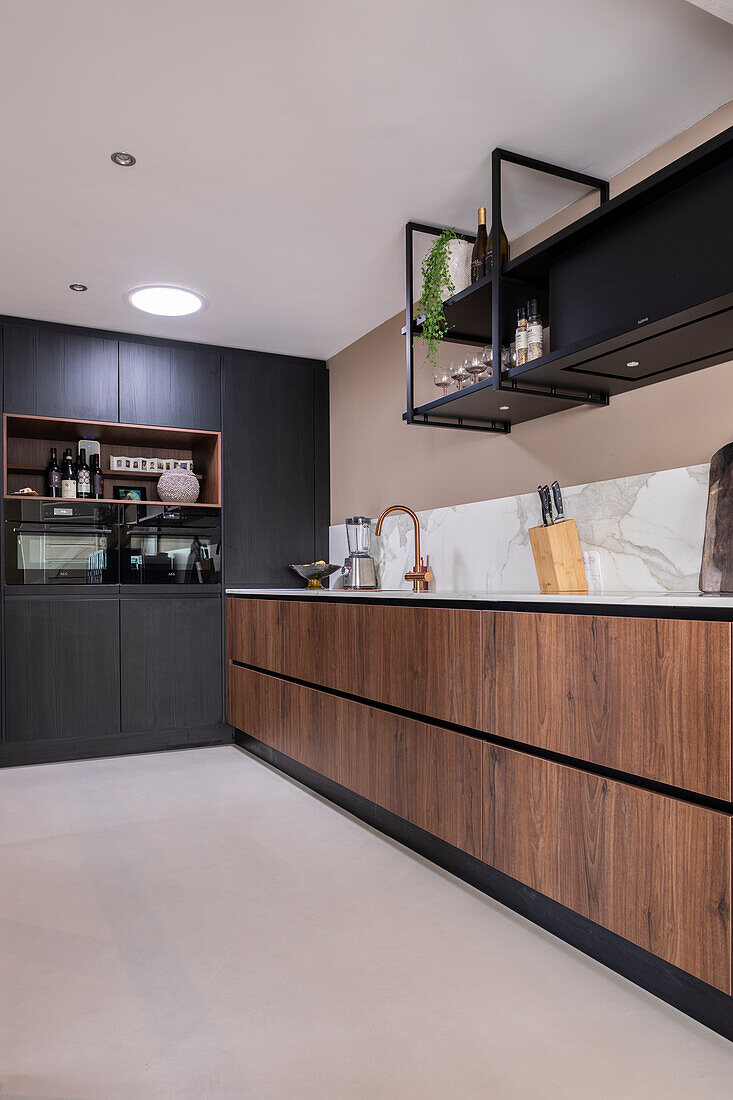 Modern kitchen with dark wooden cabinets and marbled kitchen splashback