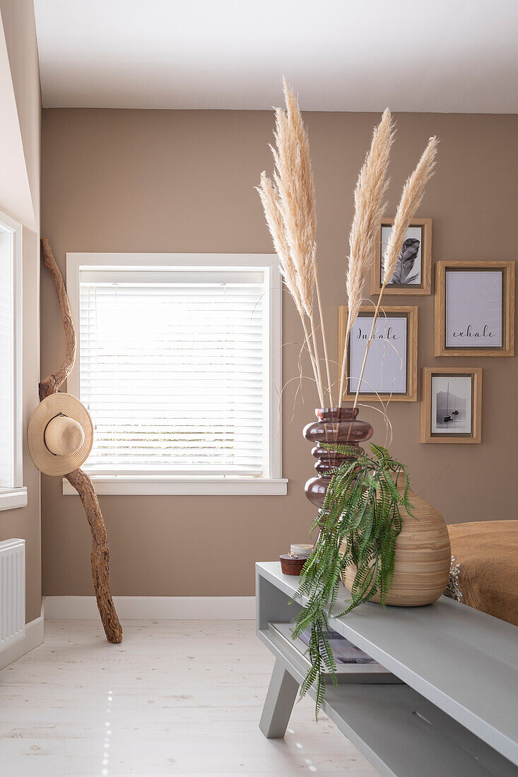 Pampas grass in vase, picture gallery on beige wall