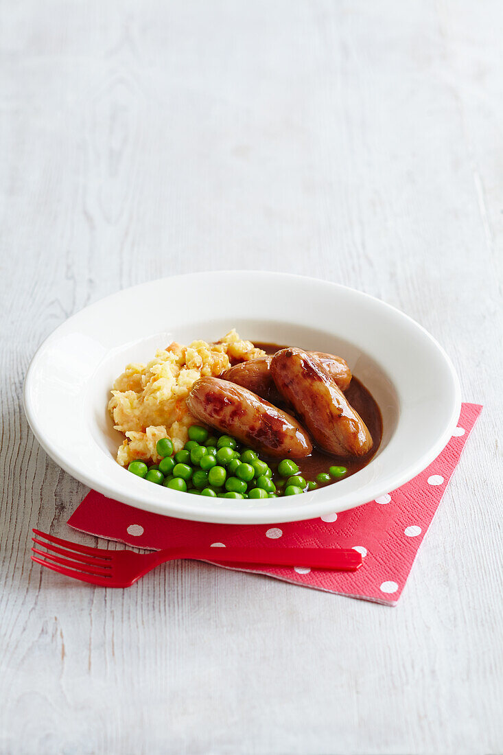 Sausages with mashed potatoes and carrots and peas in gravy