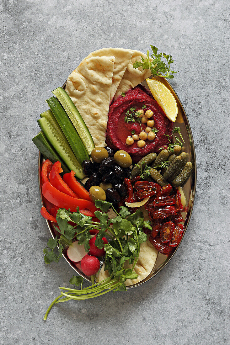 Veganer Mezze-Teller mit Rote-Bete-Hummus und verschiedenen Gemüsesorten