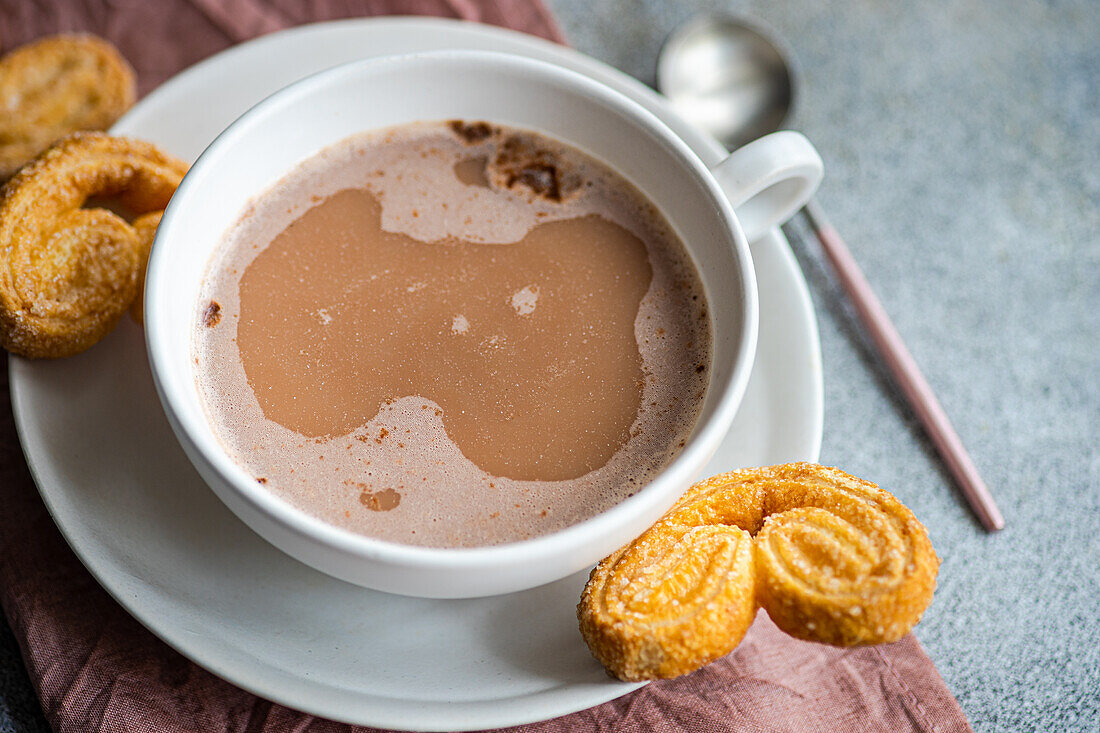 Cup of coffee with milk and palmiers