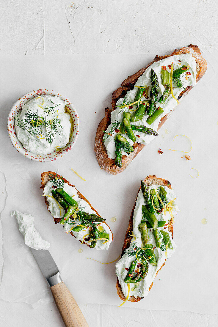 Bread topped with cream cheese spread, herbs and sautéed asparagus