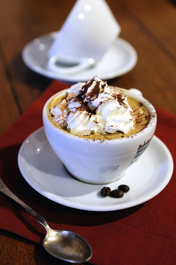 Italienischer Cappuccino mit Sahne und Schokoladenpulver