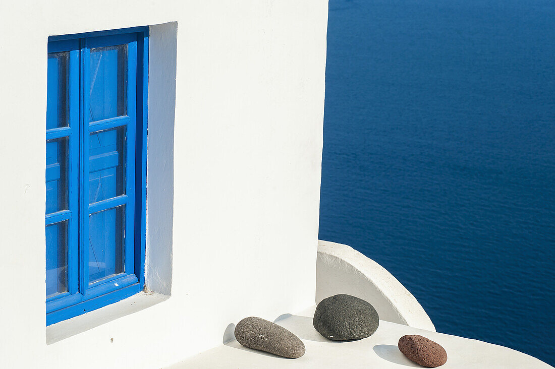 Whitewash Building With Blue Trimmed Window Along The Aegean Sea; Oia, Santorini, Greece