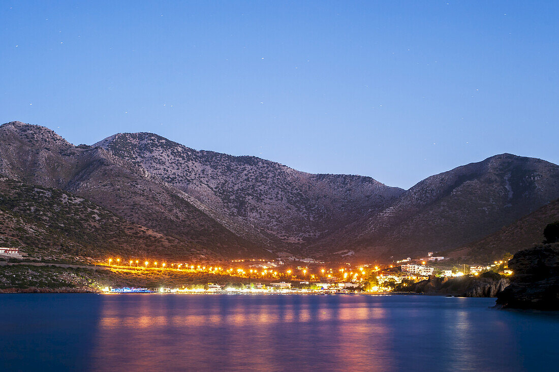 Lichter erhellen die Stadt und spiegeln sich im Wasser; Bali, Kreta, Griechenland