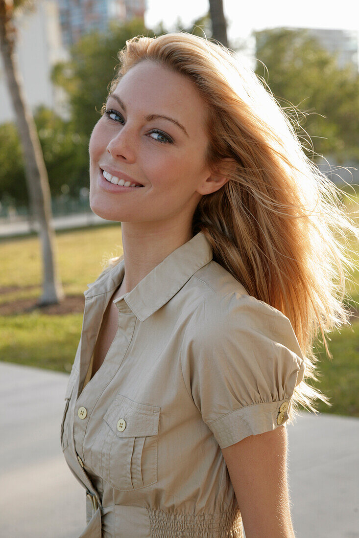 Blonde Frau in hellem Blusenkleid im Freien