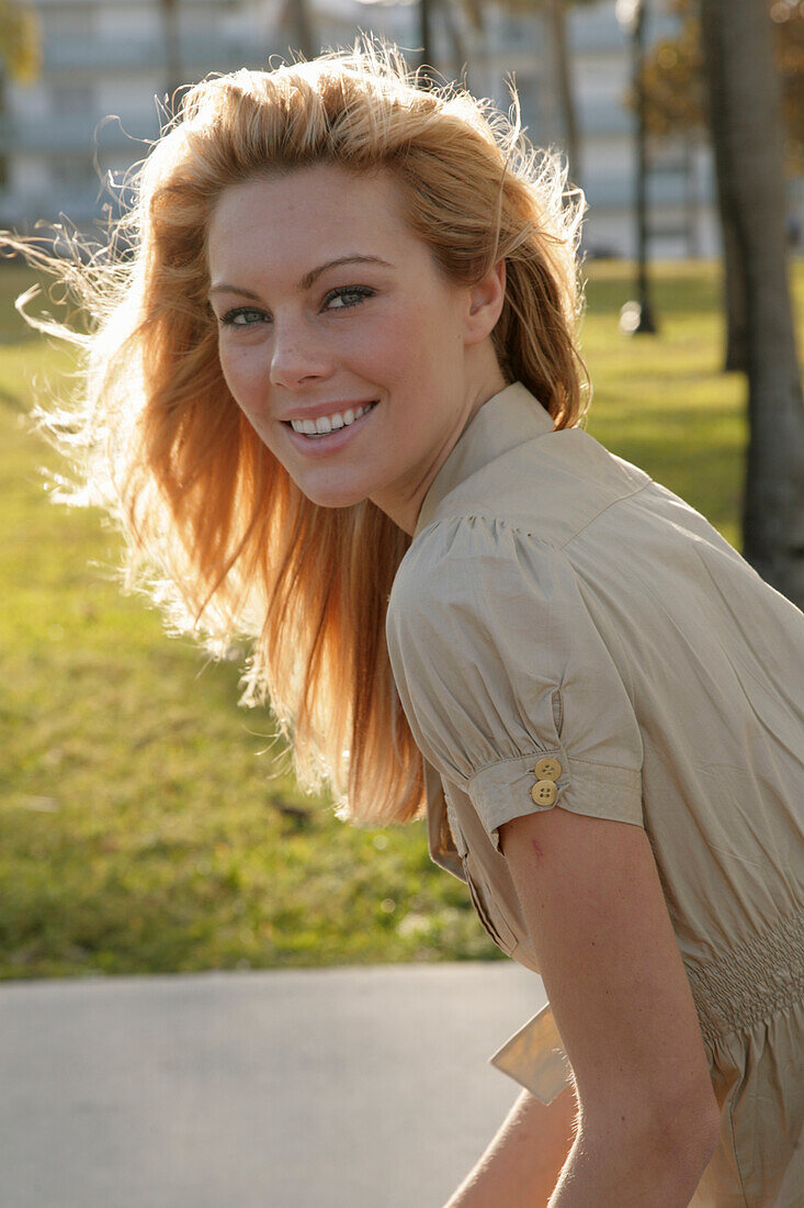 Blonde woman in light blouse dress outside