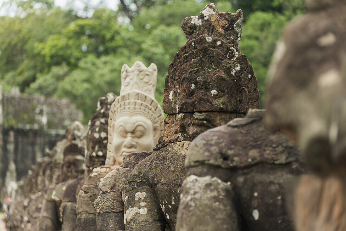 Südtor von Angkor, das Bayon Wat und Angkor Wat verbindet, in den Seitenflügeln halten viele Buddhas eine große Schlange, das Tor besteht aus einem Turm mit vier Buddha-Gesichtern; Siem Reap, Kambodscha