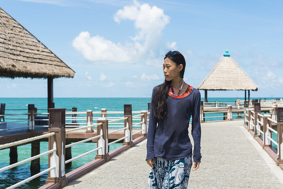 Eine junge Frau geht auf dem Pier am Independence Beach spazieren; Sihanoukville, Kambodscha