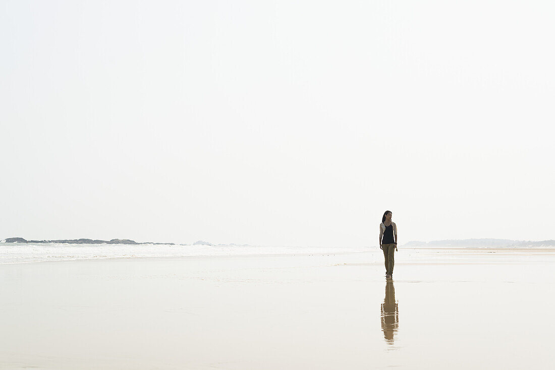 Junge Frau, die am Strand von Huohu, nördlich der Insel Kinmen, spazieren geht; Taiwan