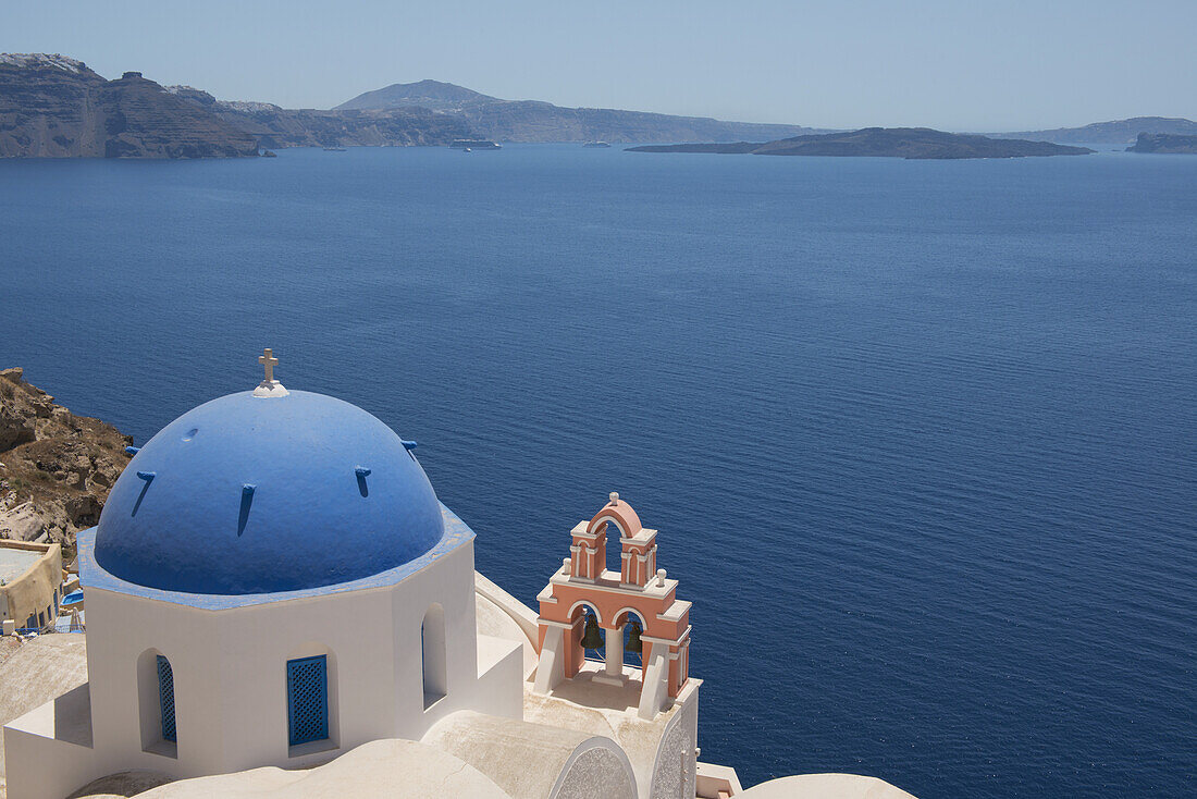 A Blue Domed Church And Pink Bell Tower Overlooking The Caldera; Oia, Santorini, Cyclades, Greek Islands, Greece