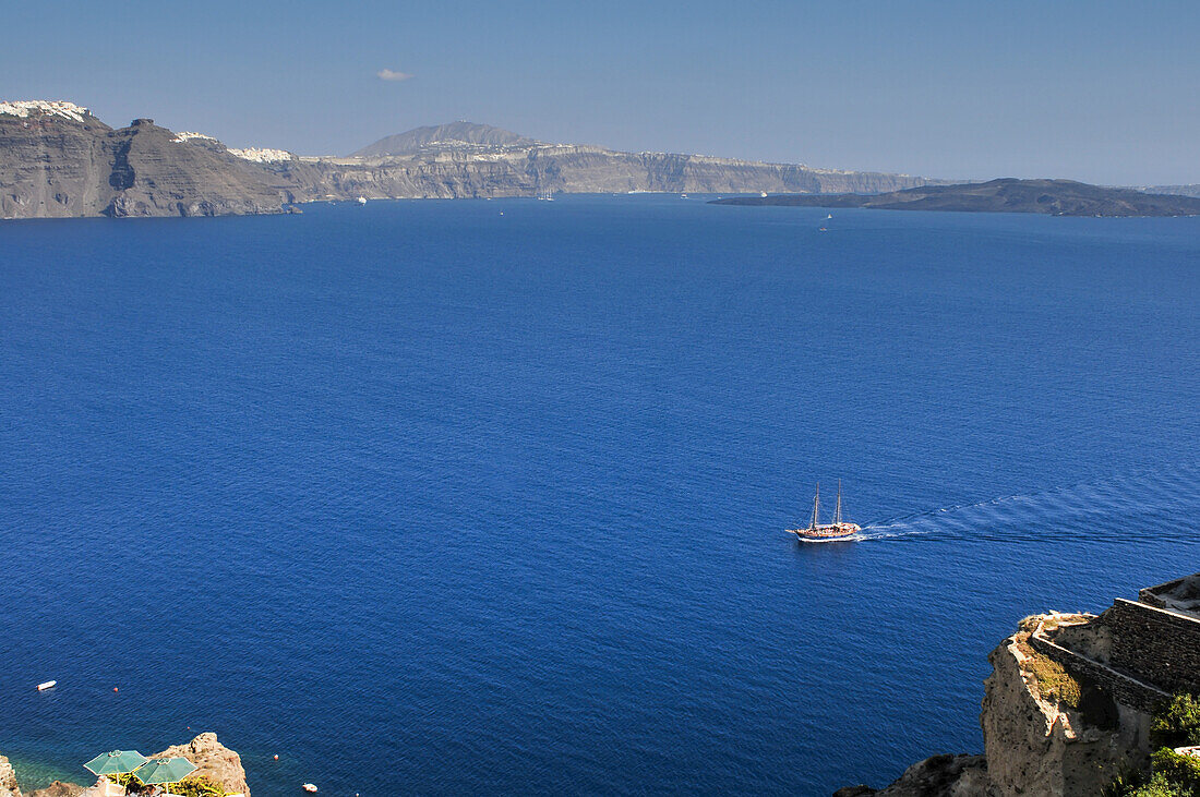 A Two-Masted Sailing Ship Plies The Caldera Of Santorini Island; Santorini, Greece