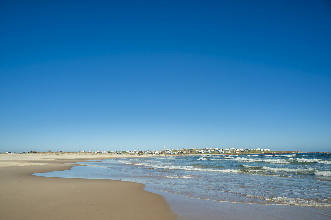 Gebäude in der Ferne und ein Sandstrand; Cabo Polonio, Uruguay