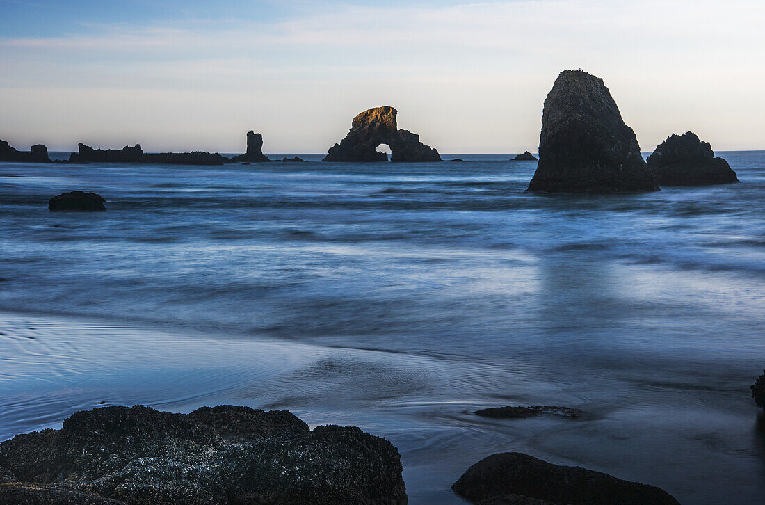Die Sonne geht über den Schornsteinen auf; Cannon Beach, Oregon, Vereinigte Staaten von Amerika