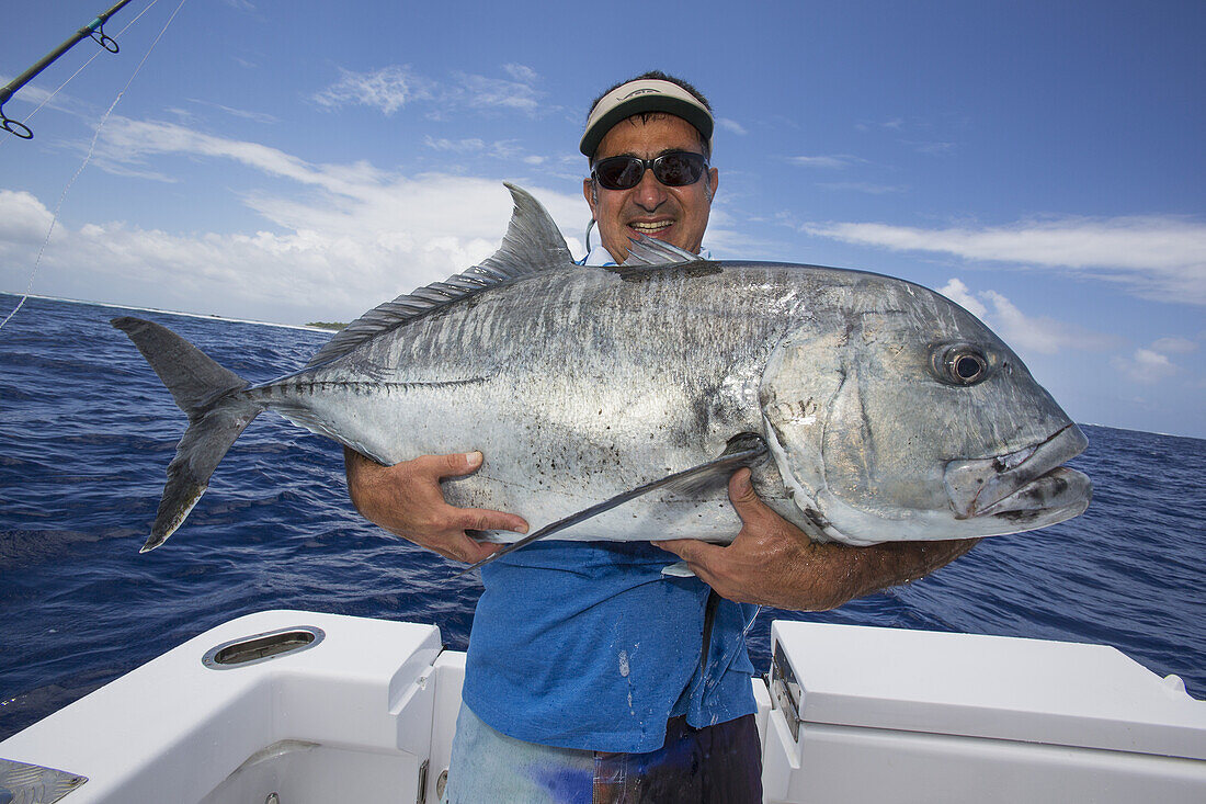 Fisherman Holding A Fresh Caught Giant Trevally Fish; Tahiti