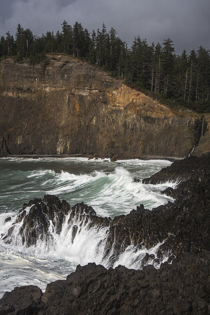 Zerklüftete Felsklippe am Cape Falcon und gegen die Felsen krachende Wellen; Manzanita, Oregon, Vereinigte Staaten von Amerika