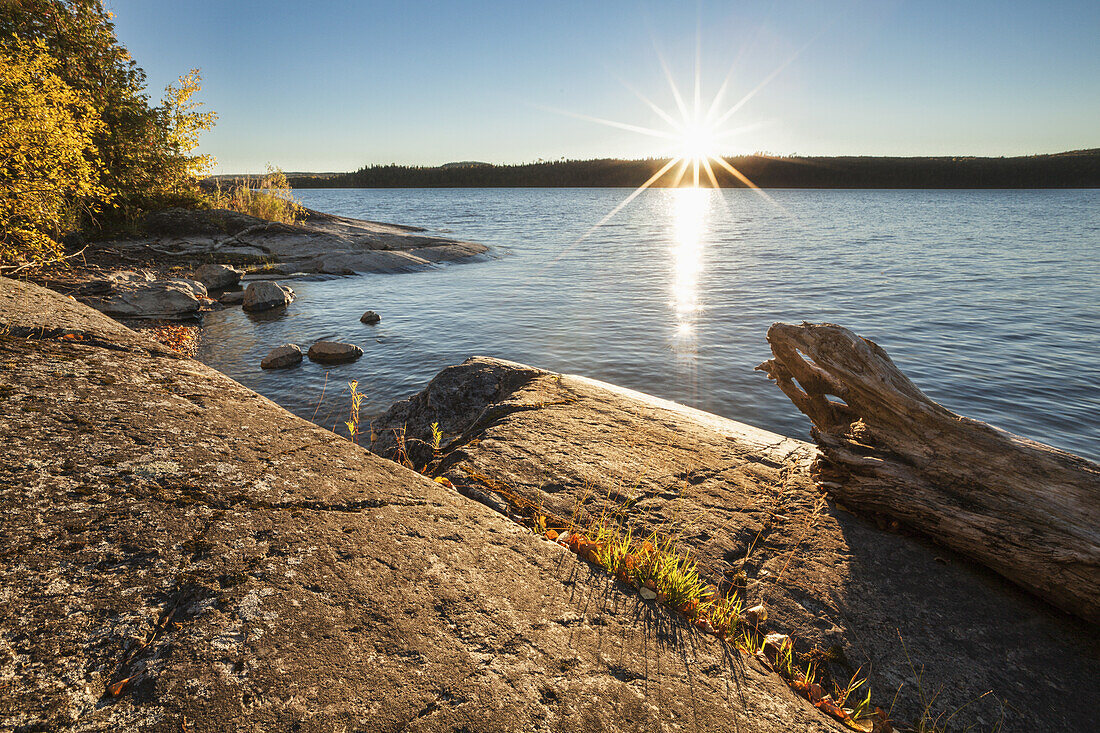 Sonnenuntergang über einem See mit Felsen; Thunder Bay, Ontario, Kanada
