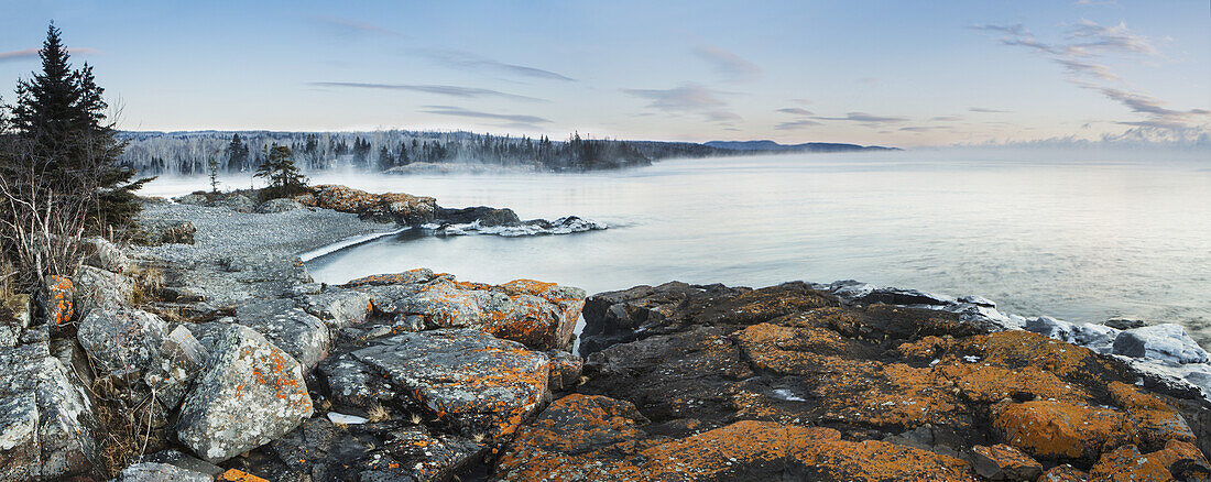 Nebel über dem Lake Superior mit Eis auf den Felsen; Thunder Bay, Ontario, Kanada