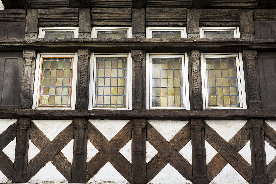 Nahaufnahme eines Fachwerkgebäudes und Details an der Seite eines Gebäudes mit Buntglasfenstern; Carhaix Plouger, Bretagne, Frankreich