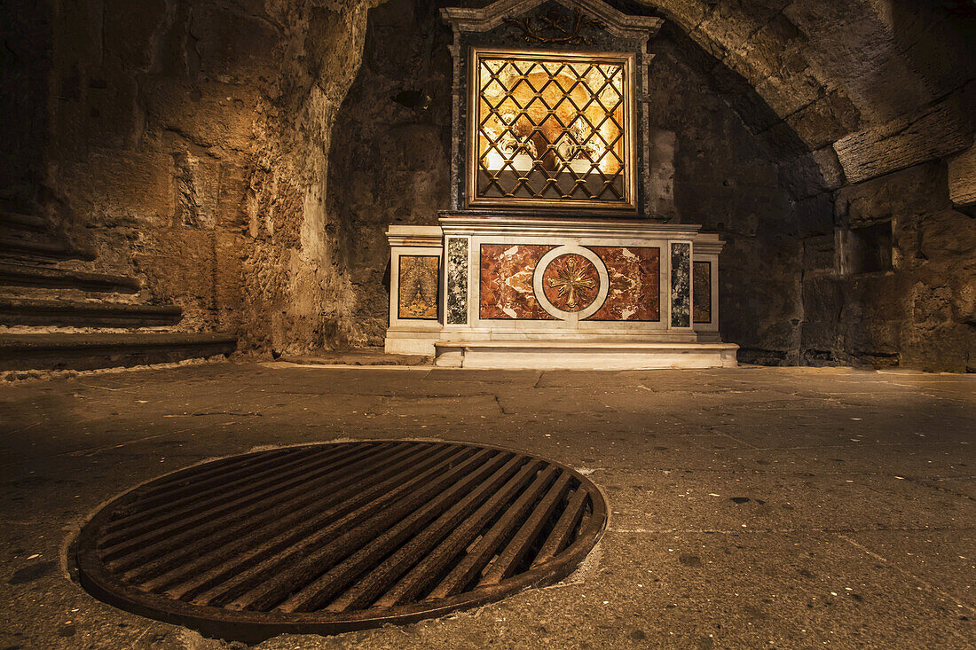 Im Inneren des Mamertinischen Gefängnisses deckt dieses Metallgitter im Boden die Stelle ab, an der die Gefangenen in ihre Gefängniszellen hinabgelassen wurden; Rom, Italien