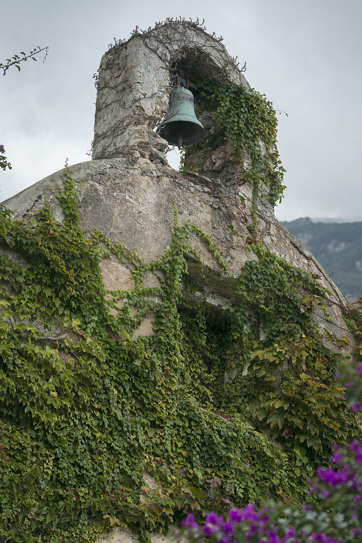 Eine grüne Glocke in einer Nische über einer mit Weinreben bedeckten Mauer; Laurito, Kampanien, Italien