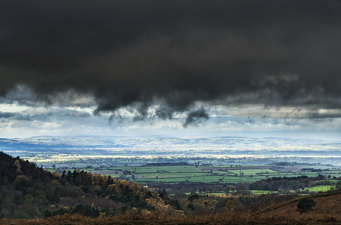 Dunkle Gewitterwolken über einer Landschaft mit grünem Ackerland; Yorkshire, England