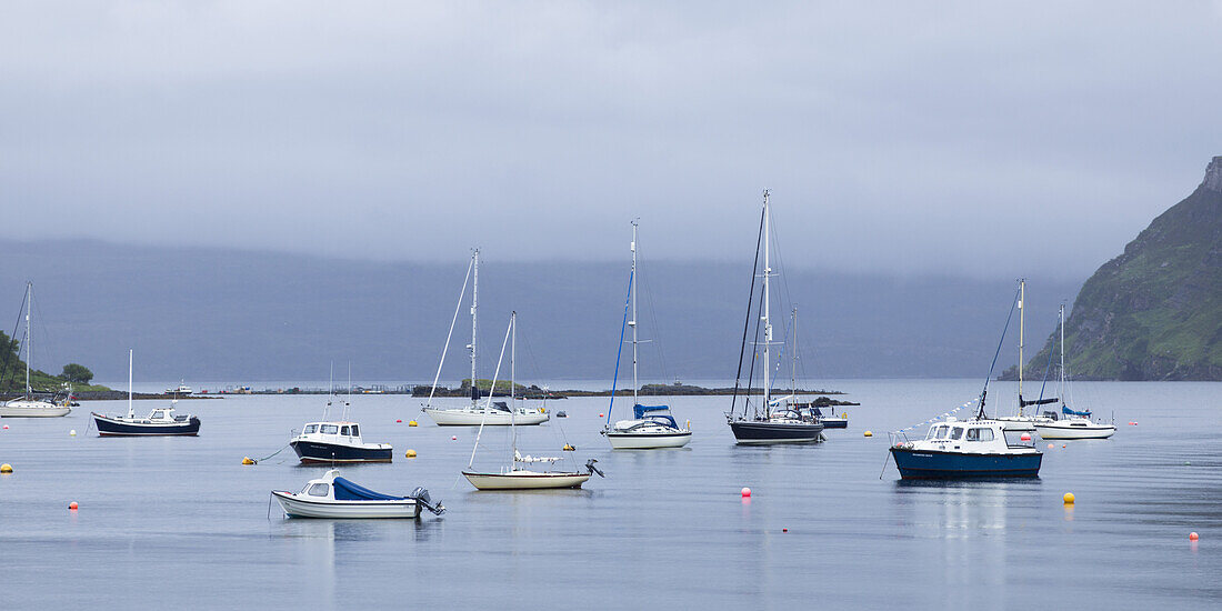 Boote in einem ruhigen Hafen von Portree; Insel Skye, Schottland