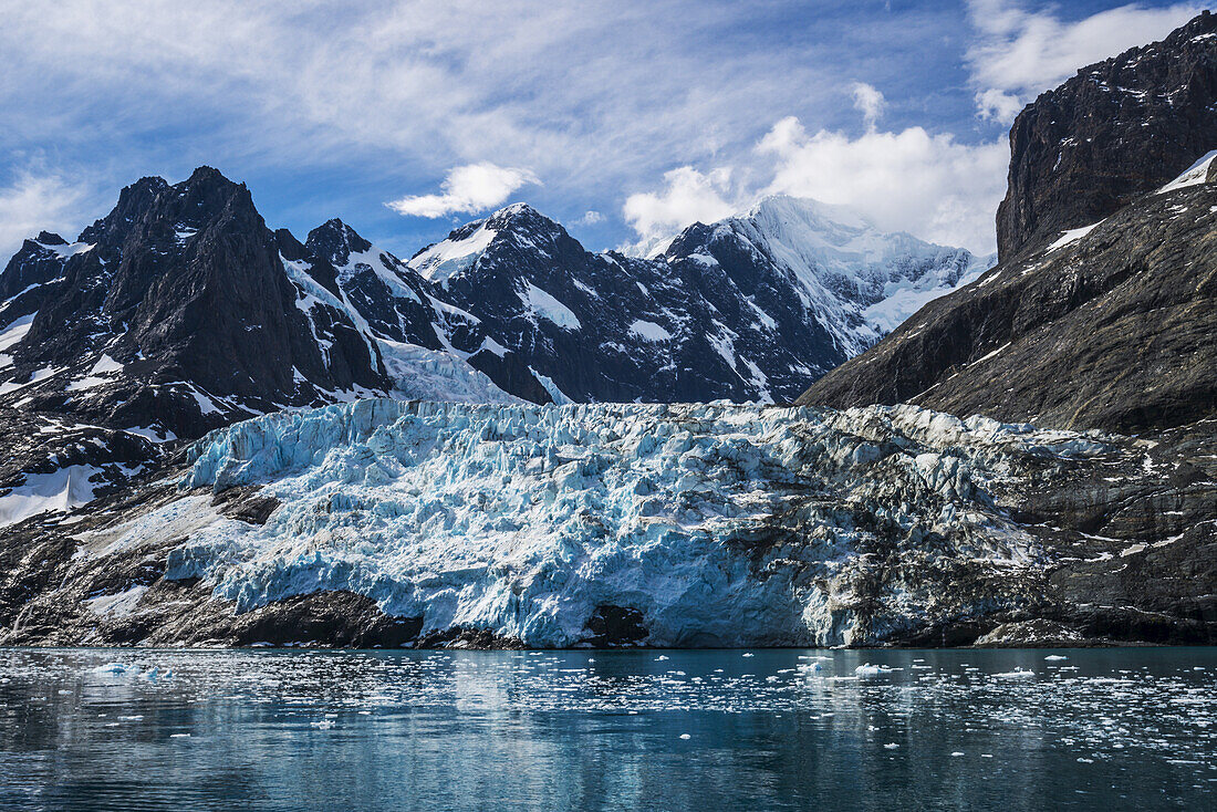 Blauer Gletscher zwischen schneebedeckten Bergen und Fjord; Antarktis