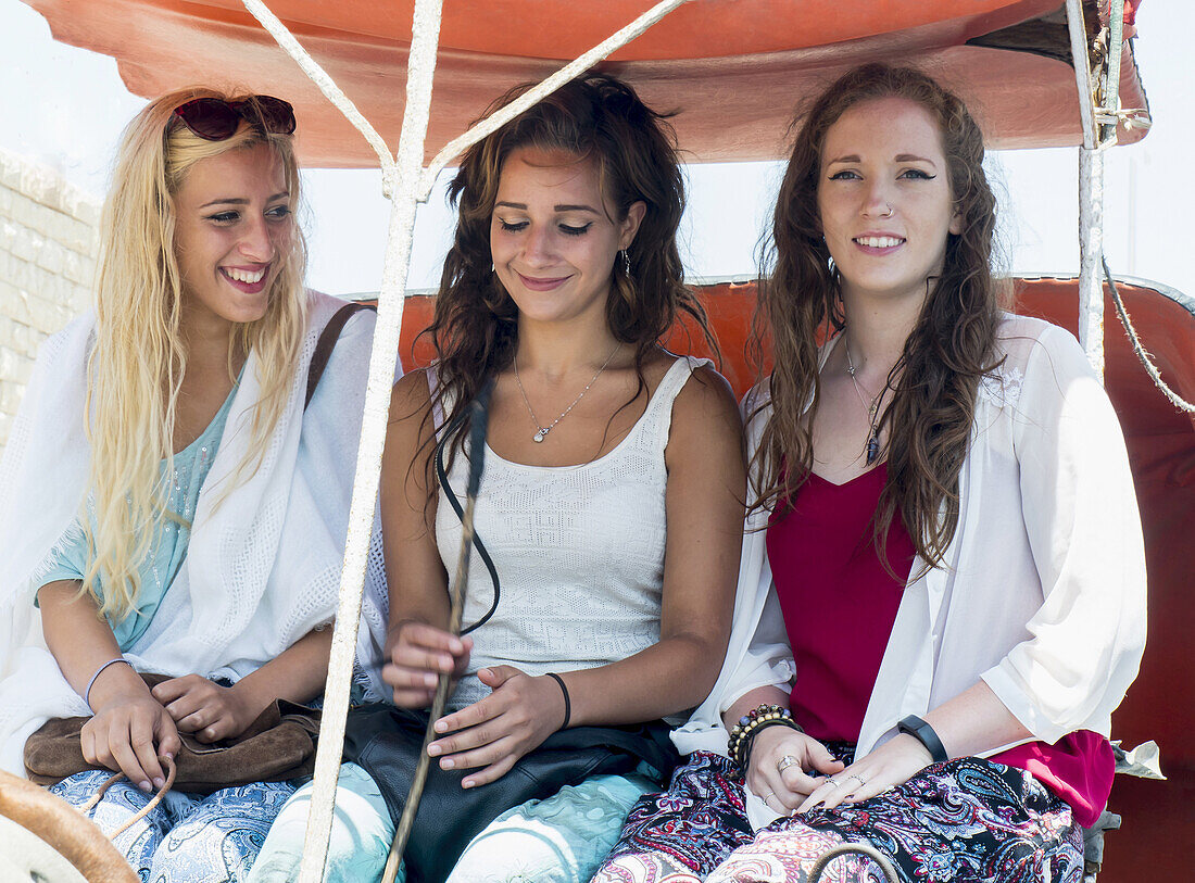 Mädchen im Teenageralter sitzen zusammen in Caleche; Marokko