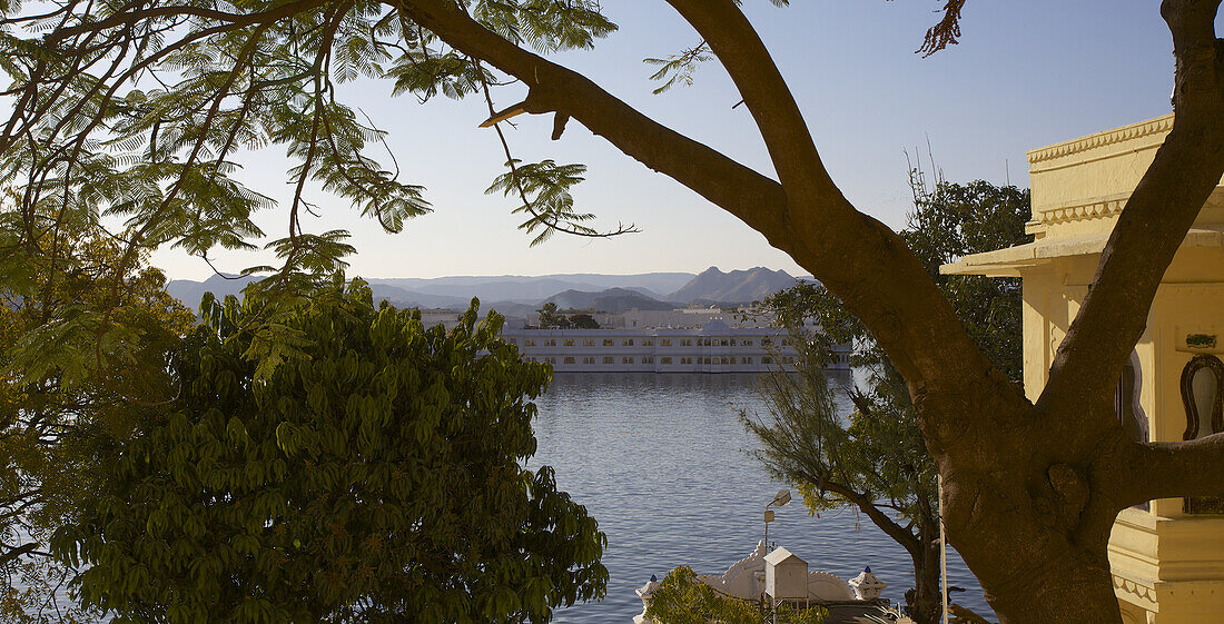 Lake Palace View From The Shore, Framed By Trees And Rajput Architecture