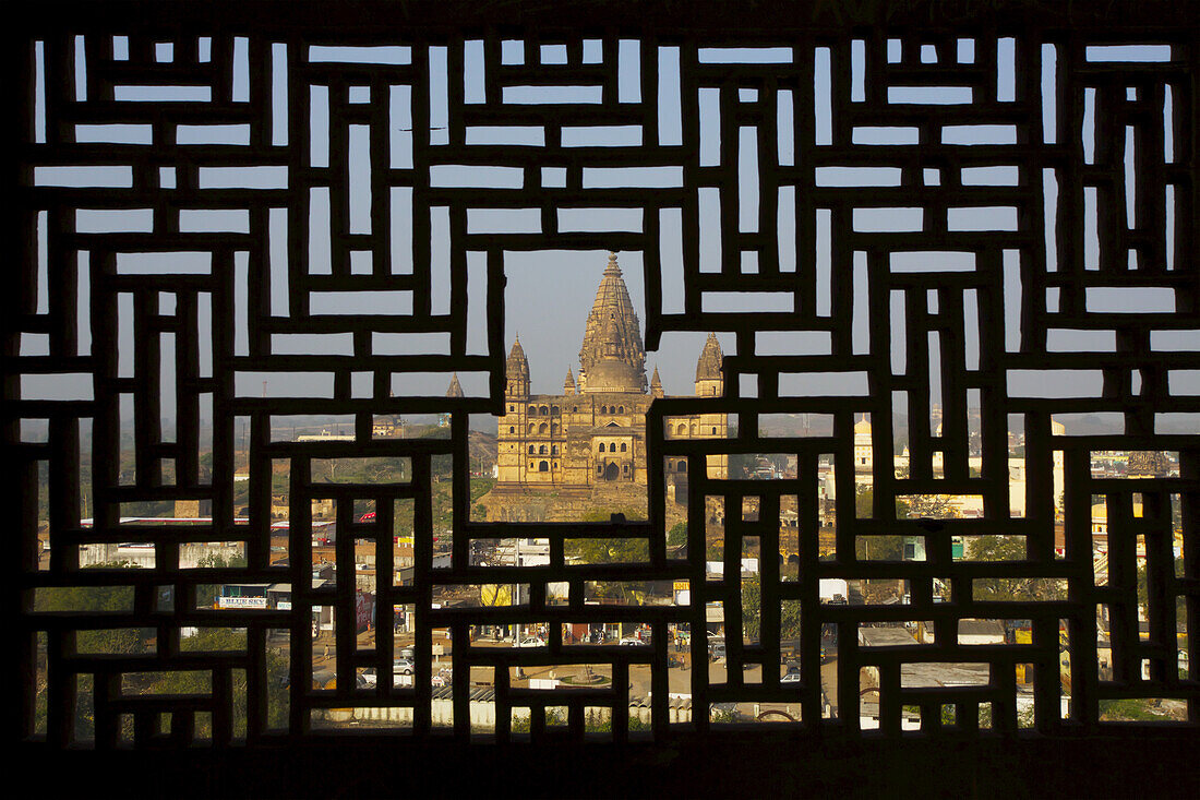Blick auf den Tempel durch das aus Stein gehauene Fenster des Rajput-Palastes