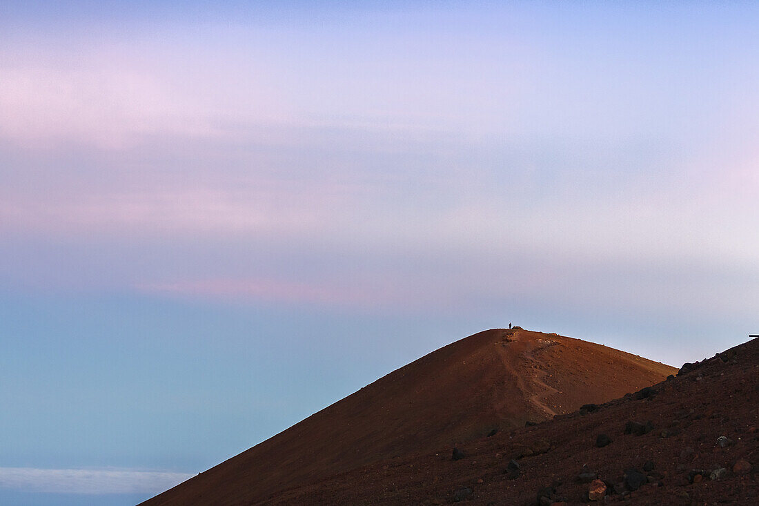 Einsame Figur auf dem 4200 Meter hohen Mauna Kea, dem höchsten Berg von Hawaii; Insel Hawaii, Hawaii, Vereinigte Staaten von Amerika