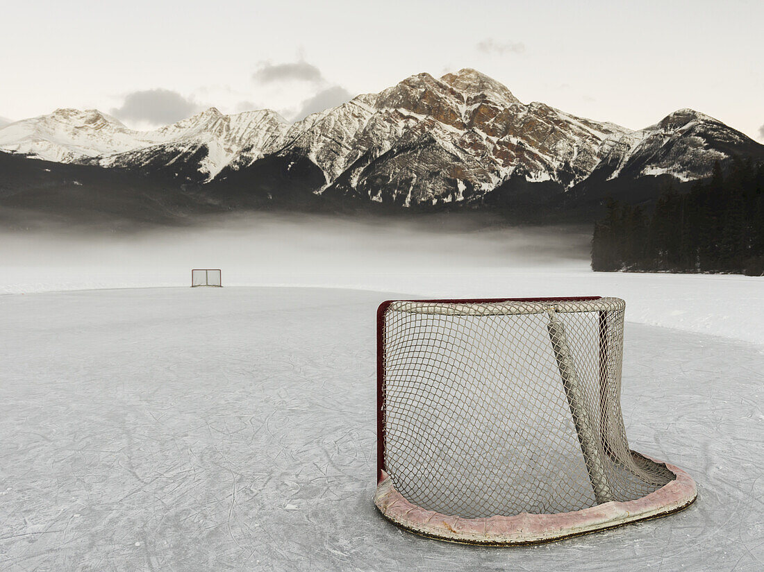 Ein Eishockeynetz auf dem gefrorenen Pyramid Lake mit der zerklüfteten Bergkette der kanadischen Rockies im Hintergrund, Jasper National Park; Alberta, Kanada