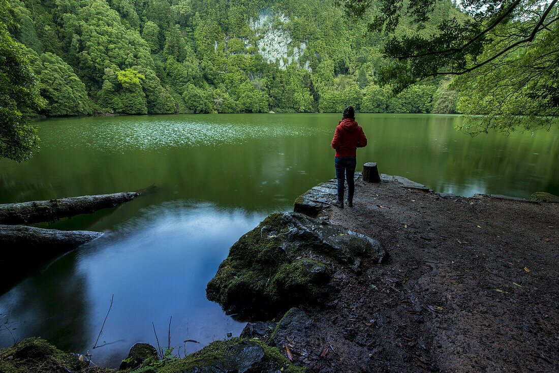 Junge Frau genießt die Ruhe der Lagoa Do Congro; Sao Miguel, Azoren, Portugal