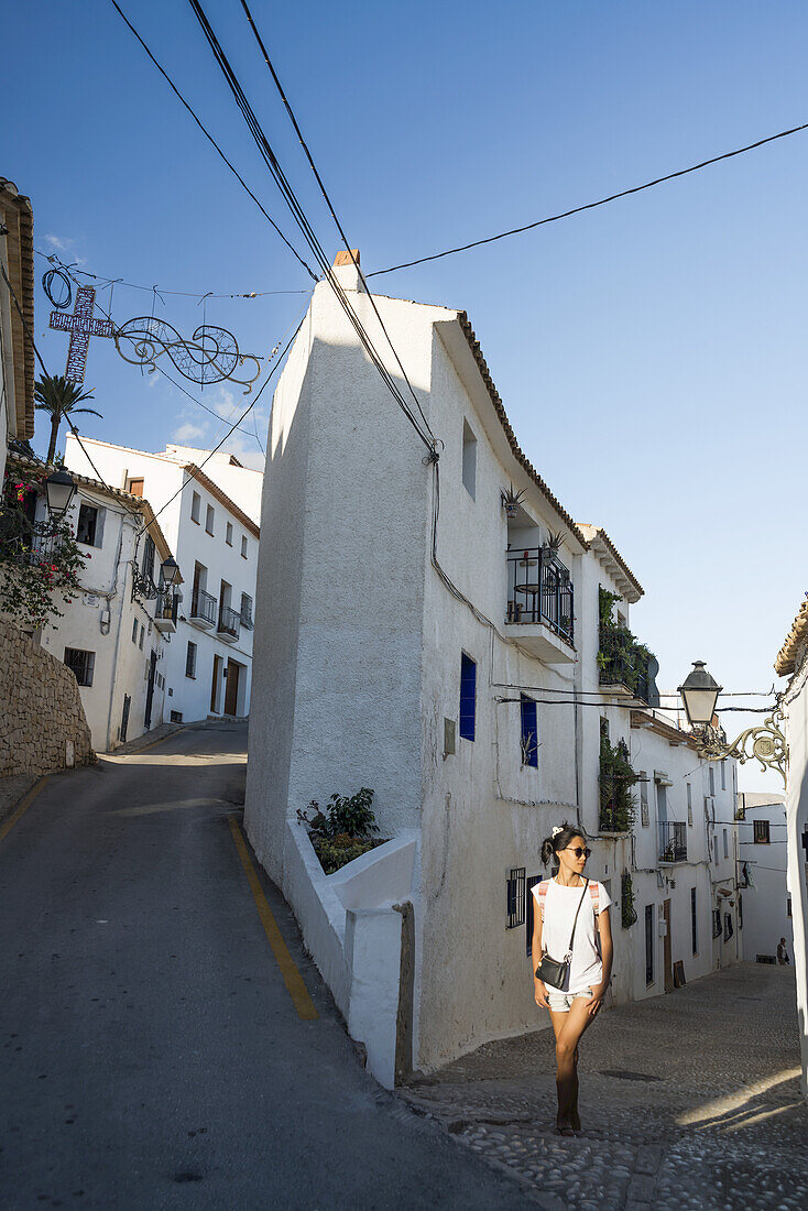A Chinese Young Woman Walking On The Street Of The Beautiful Town Of Altea In Costa Blanca; Altea, Alicante, Spain