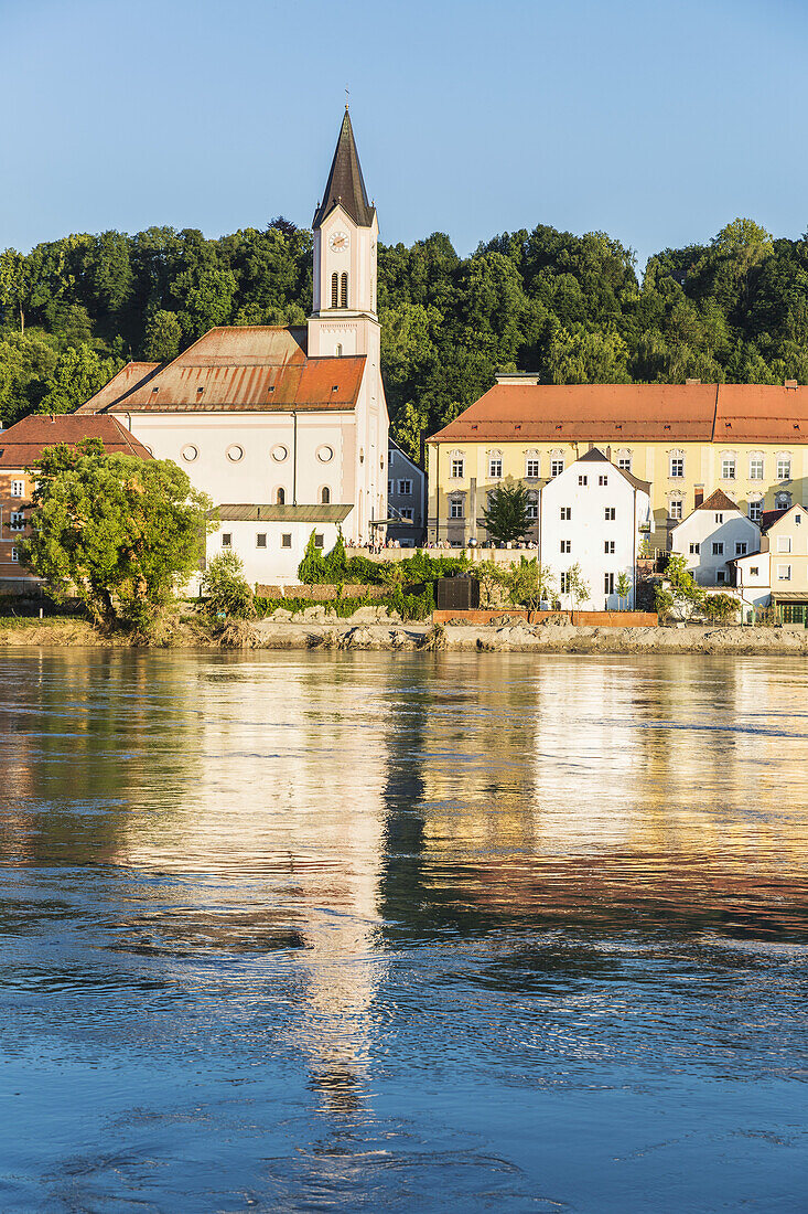 Water Reflects The Saint Gertrud Church On The River Inn; North Rhein, Westphalia, Germany