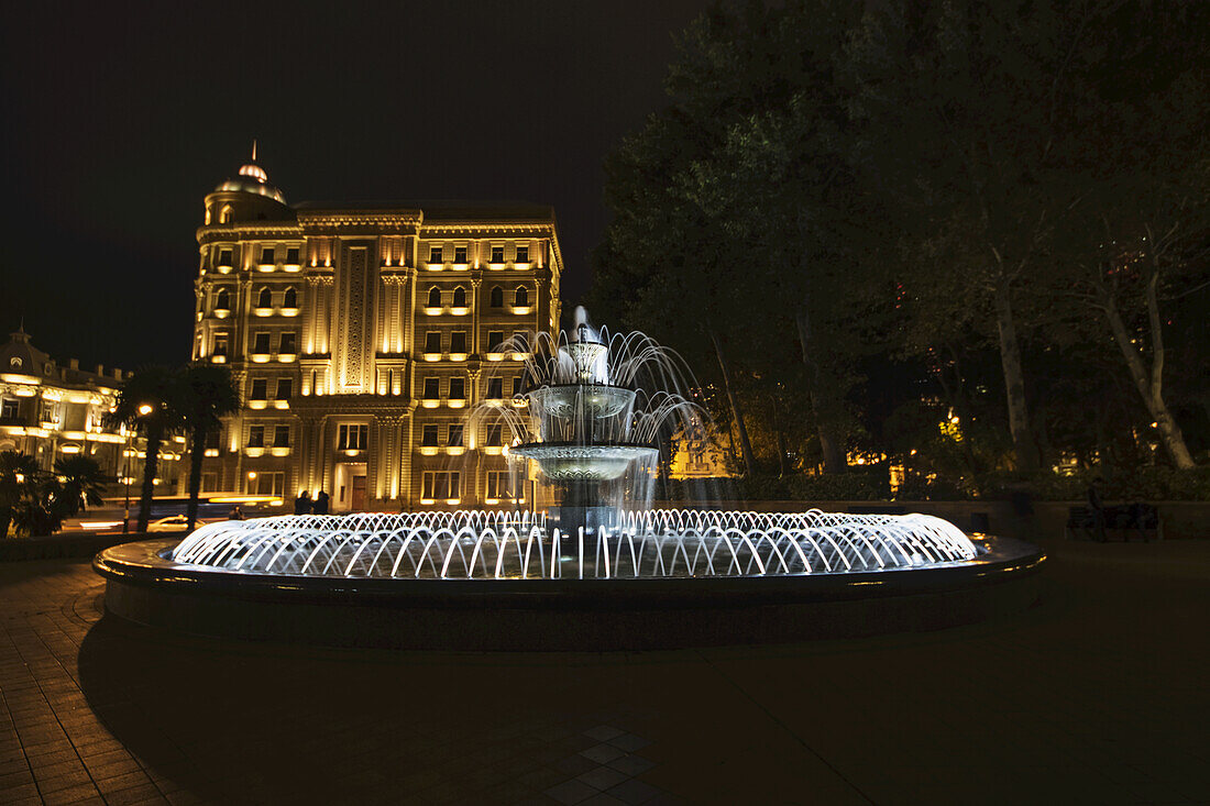 Springbrunnen mit dem Gebäude der Heydar-Aliyev-Stiftung im Hintergrund bei Nacht; Baku, Aserbaidschan