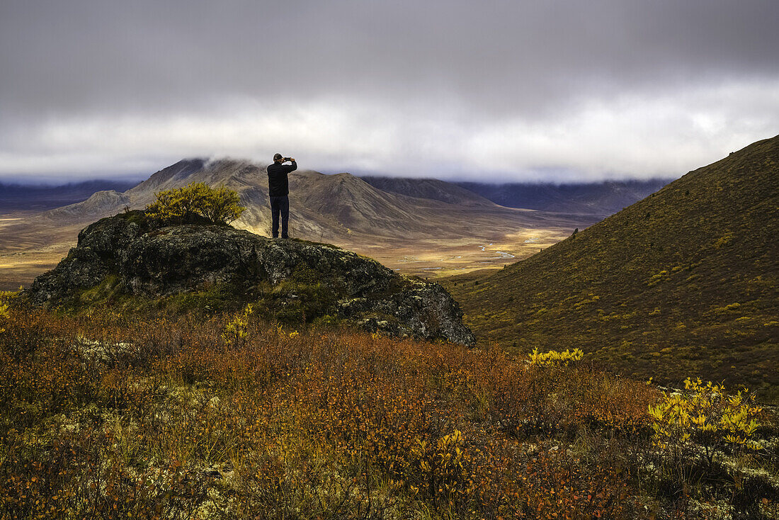 Mann, der mit einem Smart Phone Fotos macht, Dempster Highway; Yukon, Kanada