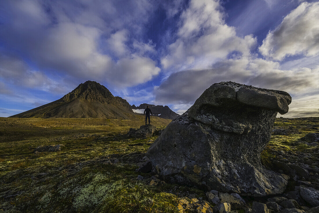 Mann, der auf einem Felsen in der isländischen Wildnis steht; Westfjorde, Island
