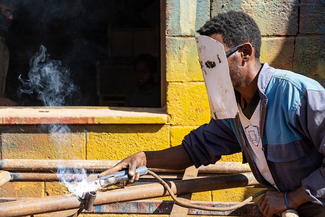Schweißer auf dem Medeber-Markt, wo Kunsthandwerker alte Reifen und Dosen zu neuen Gegenständen verarbeiten; Asmara, Zentralregion, Eritrea