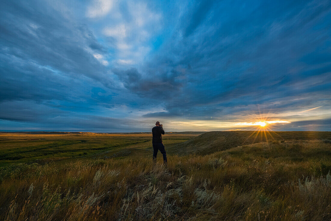 Eine Person fotografiert den Sonnenaufgang im Grasslands National Park; Saskatchewan, Kanada