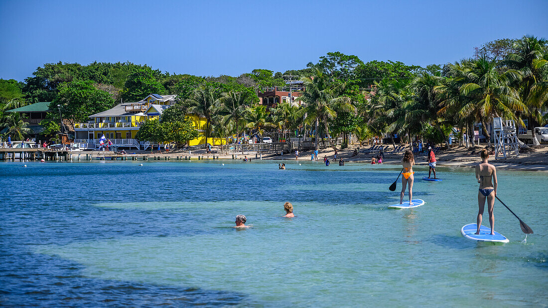 Tourists enjoying the water off the coast of West End Village; Roatan, Bay Islands Department, Honduras