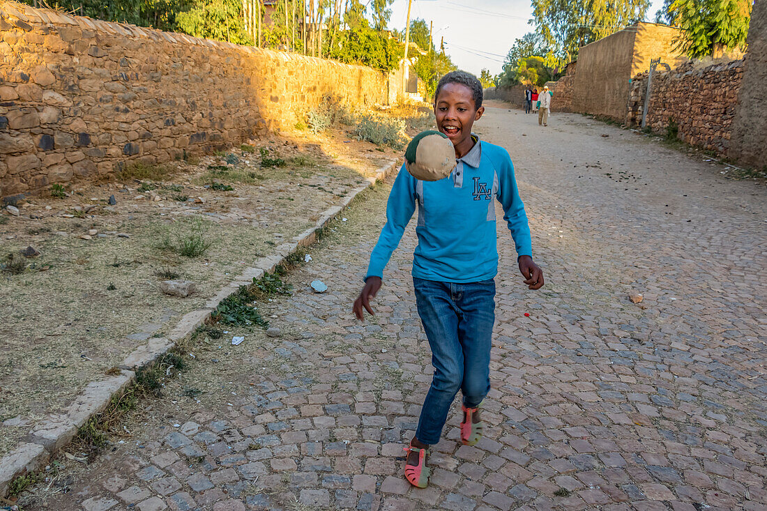 Äthiopischer Junge spielt Fußball; Axum, Tigray-Region, Äthiopien