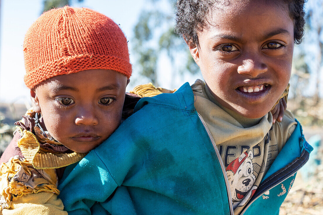 Äthiopisches Mädchen trägt einen kleinen Jungen, Simien-Gebirge; Region Amhara, Äthiopien