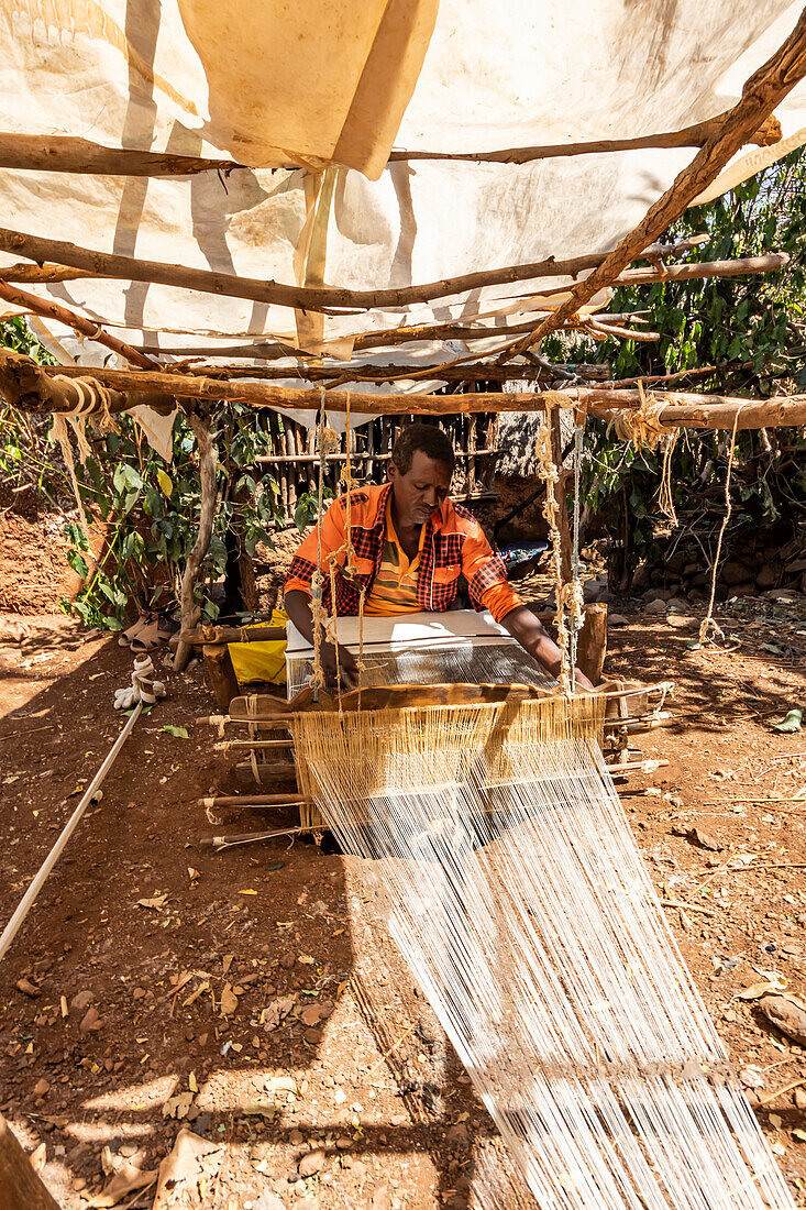 Konso man weaving cloth on his loom; Karat-Konso, Southern Nations Nationalities and Peoples' Region, Ethiopia