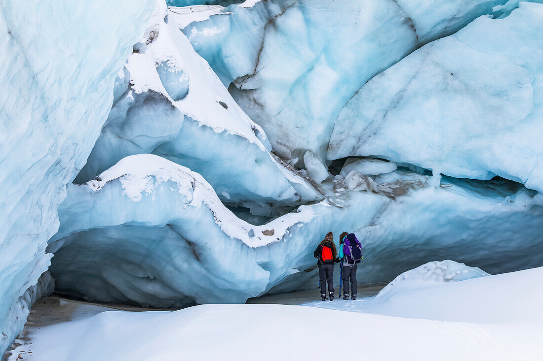Zwei Winterwanderer untersuchen das Eis des Black Rapids Glacier; Alaska, Vereinigte Staaten von Amerika